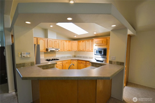 21628 SE 272nd Pl Unit 138, Maple Valley, WA 98038 - kitchen featuring stainless steel appliances, under cabinet range hood, light carpet, a skylight, and light brown cabinets