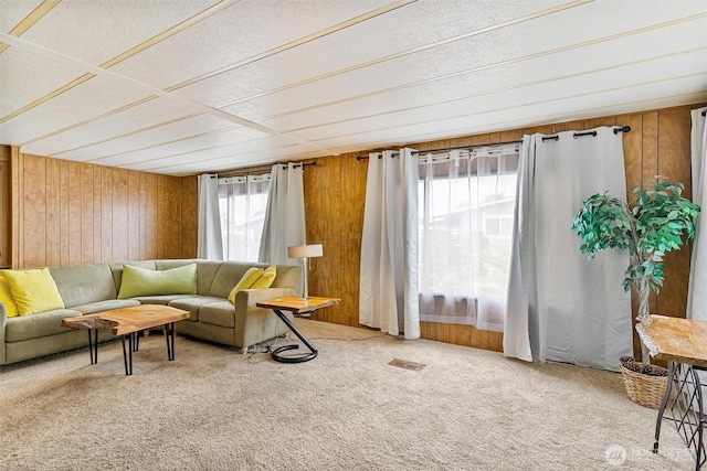carpeted living room featuring wood walls