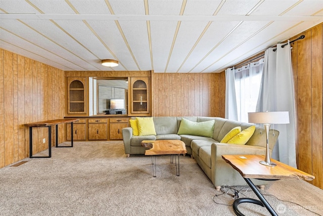 living room with wood walls, carpet floors, and built in features