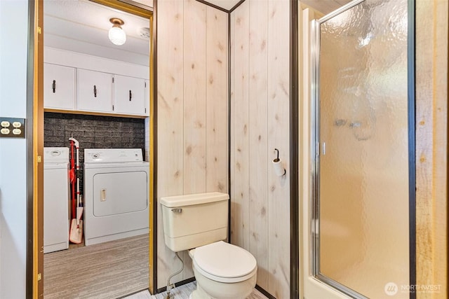full bath featuring separate washer and dryer, a shower stall, and toilet