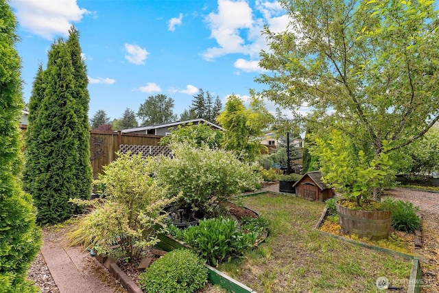 view of yard featuring fence and a vegetable garden