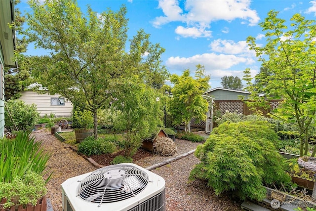 view of yard with central AC, a garden, and fence