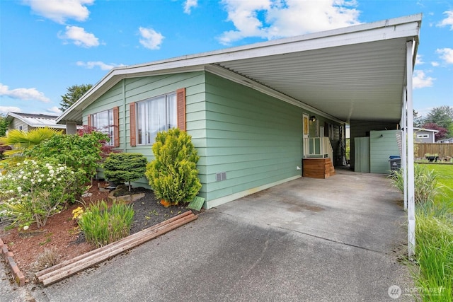 view of side of property with an attached carport and driveway