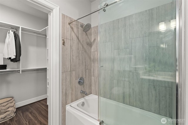 full bath with bath / shower combo with glass door, wood finished floors, and baseboards