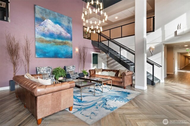 living room with a high ceiling, baseboards, stairs, recessed lighting, and a chandelier