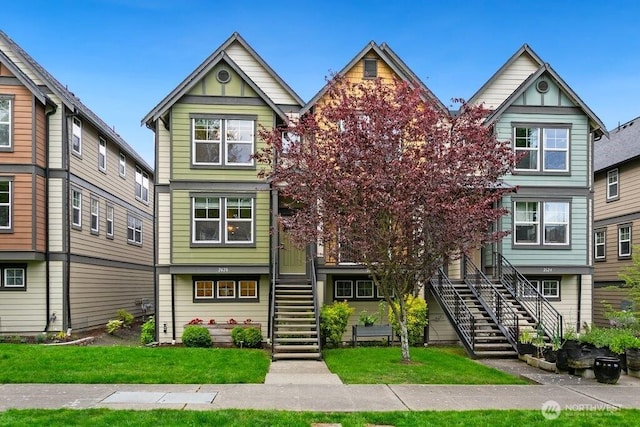 multi unit property with stairway and a front yard