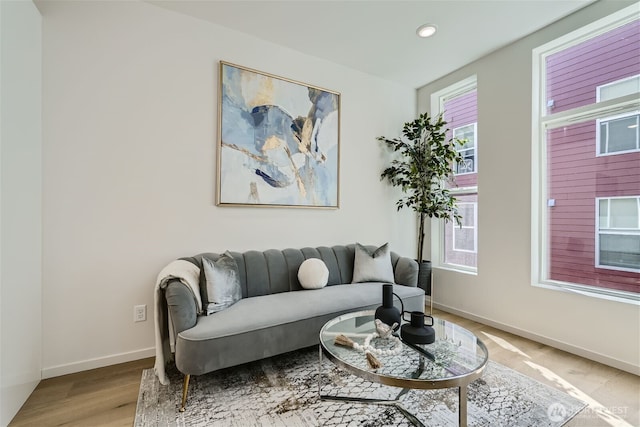living area with baseboards, recessed lighting, and light wood-style floors