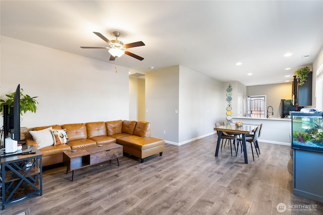 living room with recessed lighting, ceiling fan, light wood-type flooring, visible vents, and baseboards