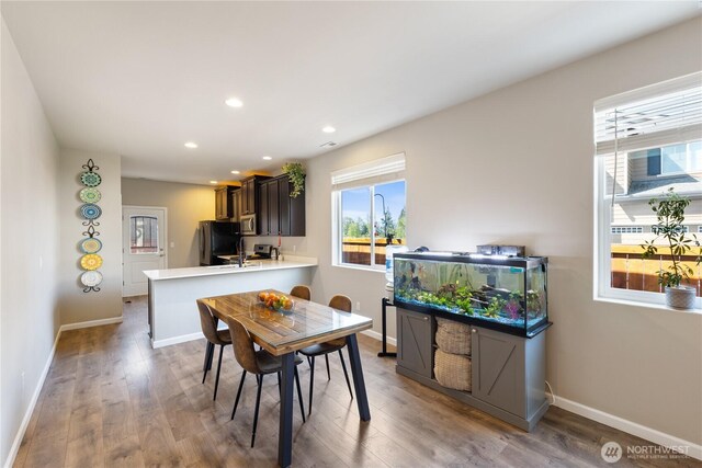 dining space with recessed lighting, wood finished floors, and baseboards