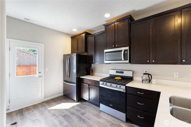 kitchen with recessed lighting, light wood finished floors, appliances with stainless steel finishes, and light countertops