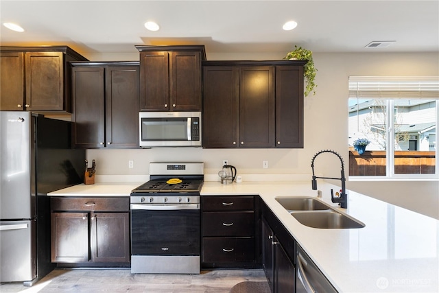 kitchen featuring recessed lighting, a sink, appliances with stainless steel finishes, and light countertops