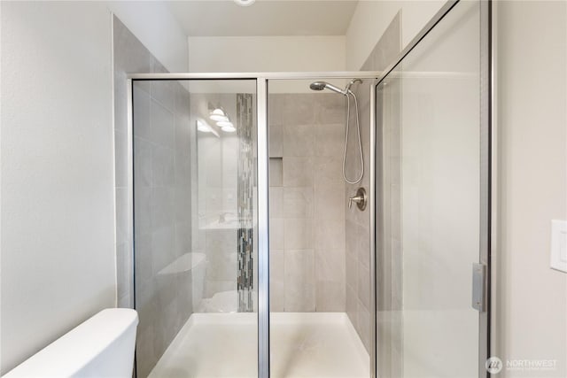 full bath featuring toilet and a stall shower