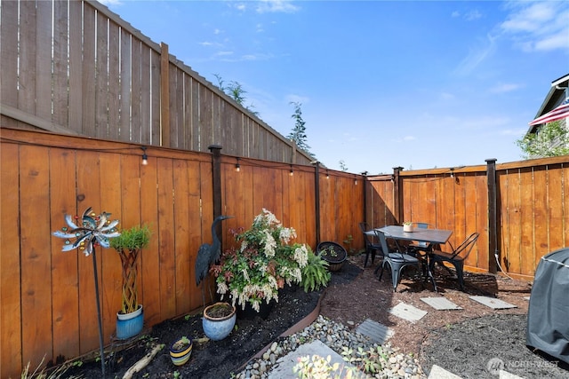 view of yard with outdoor dining space and a fenced backyard