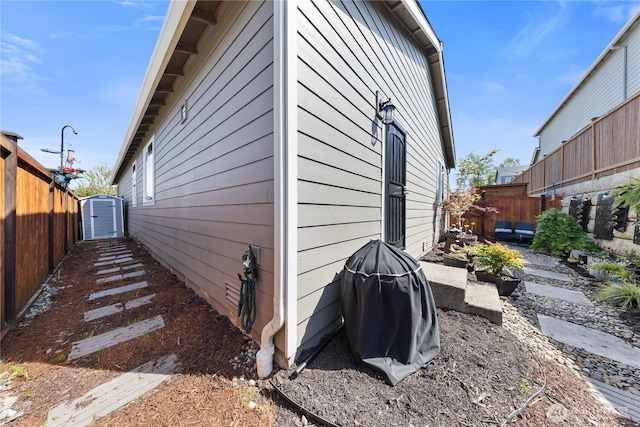 view of property exterior featuring an outdoor structure, a storage unit, and a fenced backyard
