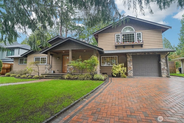 view of front facade featuring stone siding, decorative driveway, a front yard, and a garage