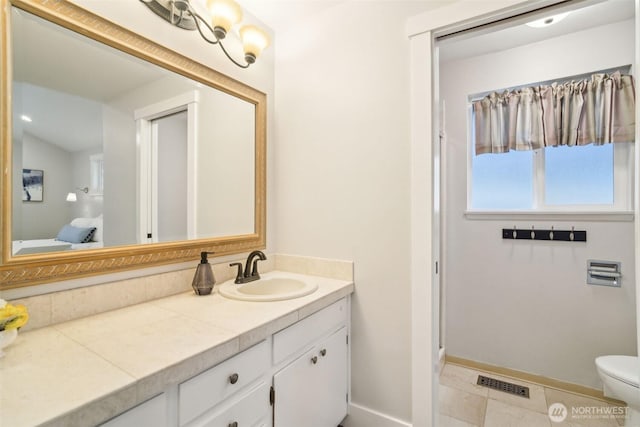 bathroom featuring toilet, visible vents, vanity, and baseboards