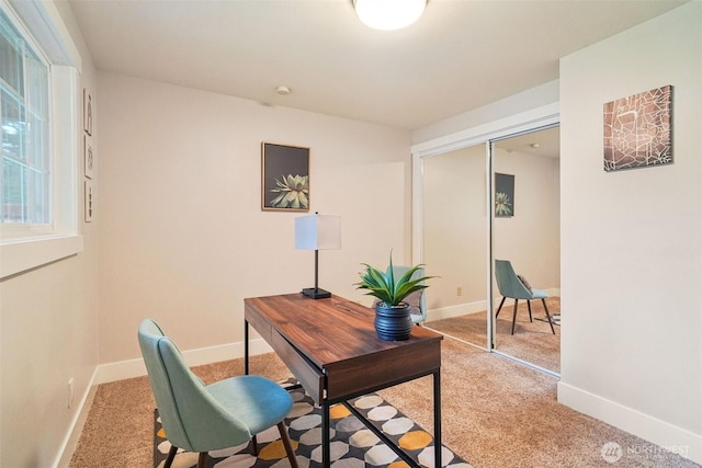 office space with baseboards and light colored carpet