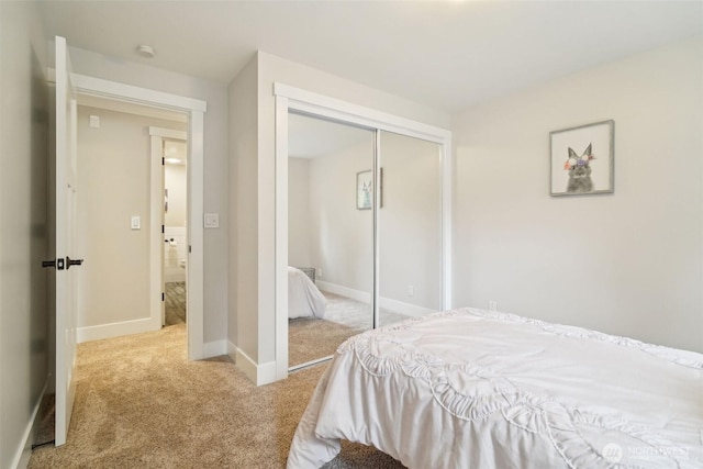 bedroom with baseboards, a closet, and carpet flooring