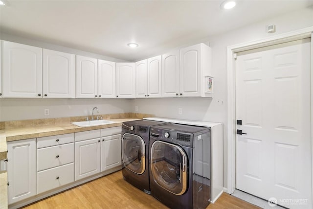 laundry room featuring recessed lighting, a sink, light wood-style floors, and washer and clothes dryer