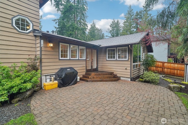 rear view of property with fence and a patio area