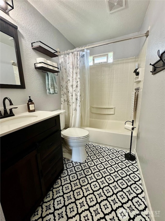 full bathroom featuring vanity, tile patterned floors, toilet, visible vents, and a textured wall