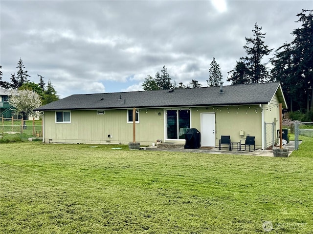 rear view of house featuring fence, a patio area, and a lawn
