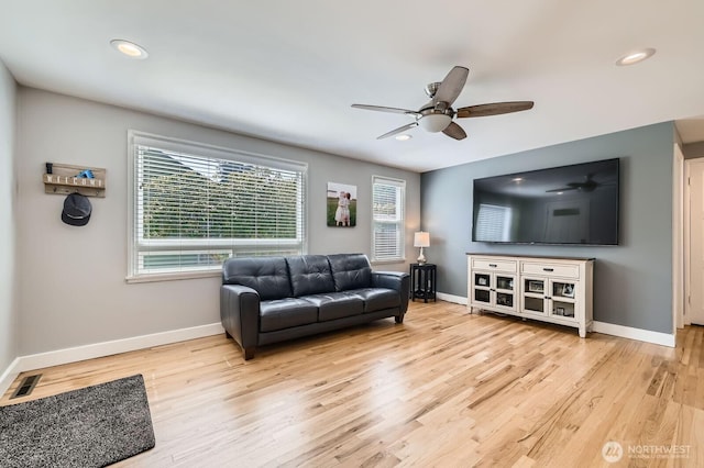 living area featuring wood finished floors, visible vents, and baseboards