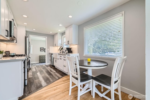 dining room featuring recessed lighting, wood finished floors, and baseboards