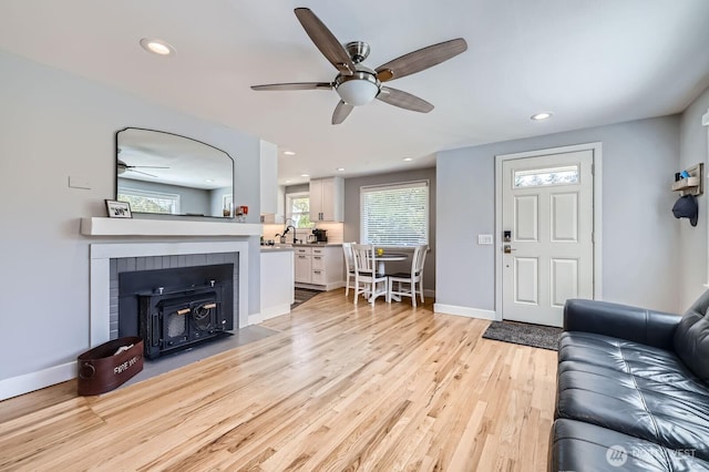living room with baseboards, recessed lighting, ceiling fan, and light wood finished floors