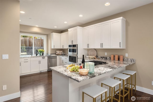 12009 SE 81st Ln, Newcastle, WA 98056 - kitchen with baseboards, stainless steel appliances, light stone counters, and a sink