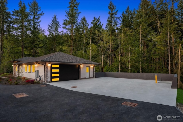12009 SE 81st Ln, Newcastle, WA 98056 - garage at dusk featuring a wooded view