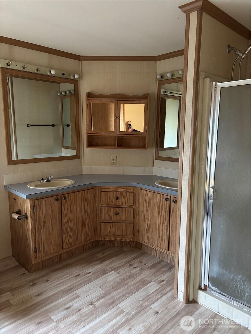9101 Steilacoom Rd SE Unit 158, Olympia, WA 98513 - bathroom with double vanity, wood finished floors, crown molding, a shower stall, and decorative backsplash