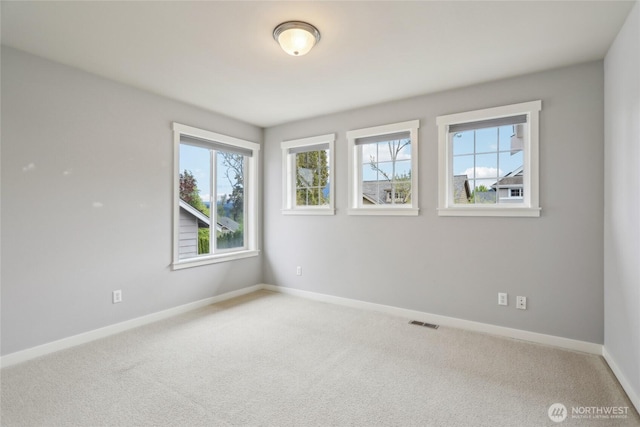 unfurnished room with visible vents, carpet flooring, and baseboards