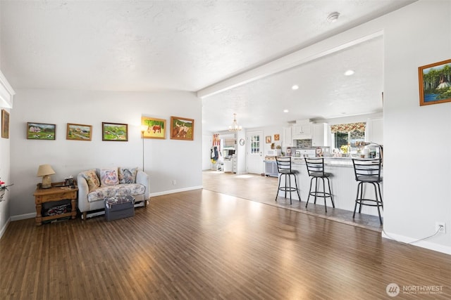103 Secluded Way, Sequim, WA 98382 - living area with lofted ceiling with beams, a notable chandelier, dark wood finished floors, and baseboards
