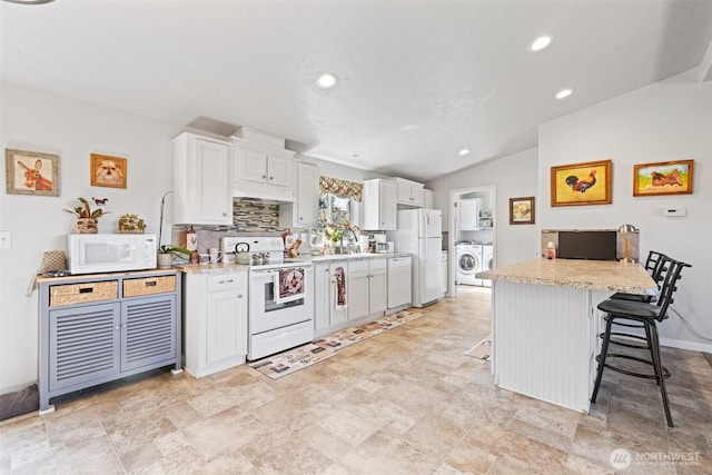 103 Secluded Way, Sequim, WA 98382 - kitchen featuring light countertops, a kitchen bar, independent washer and dryer, and white appliances