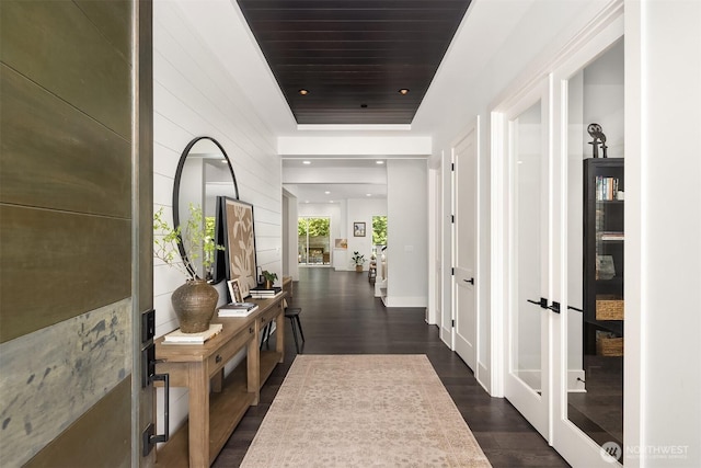 hall with recessed lighting, wood walls, and dark wood-style floors