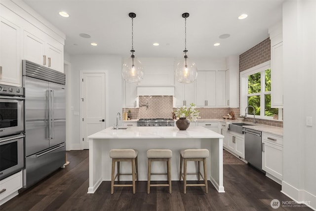 kitchen with a sink, white cabinetry, appliances with stainless steel finishes, and tasteful backsplash