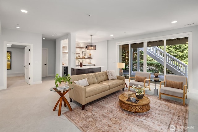 living area featuring baseboards, light carpet, and recessed lighting
