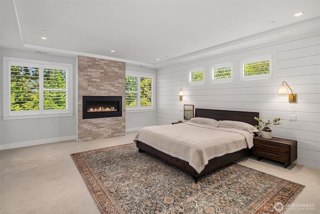carpeted bedroom featuring a tiled fireplace, recessed lighting, and baseboards