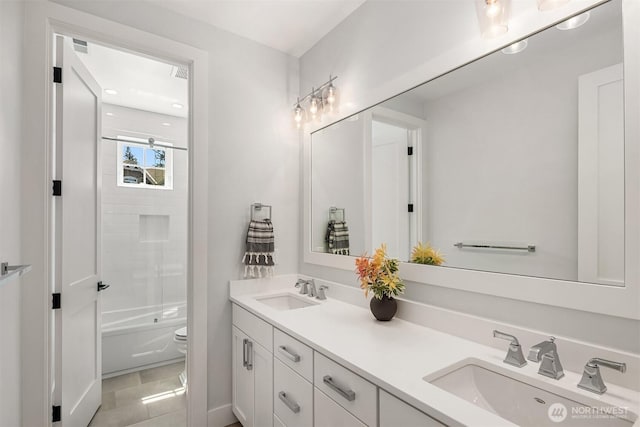 bathroom featuring a sink, toilet, double vanity, and  shower combination