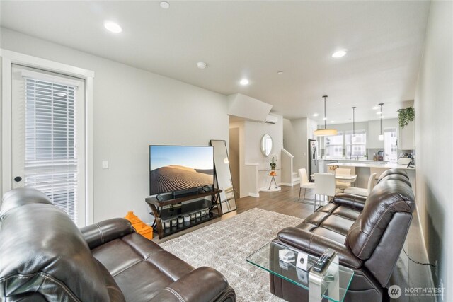 living room with recessed lighting, baseboards, and wood finished floors