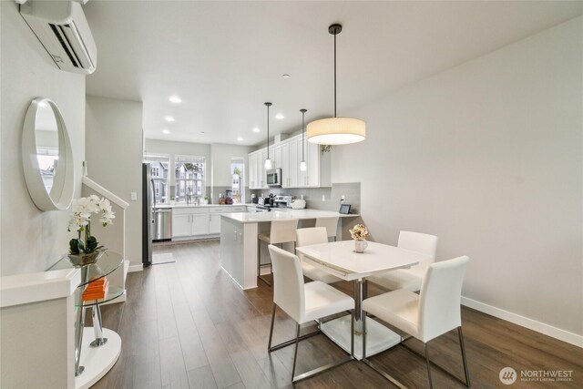 dining room featuring recessed lighting, baseboards, dark wood-style flooring, and a wall mounted air conditioner