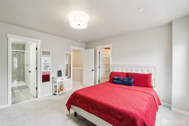 bedroom with carpet floors, baseboards, and connected bathroom