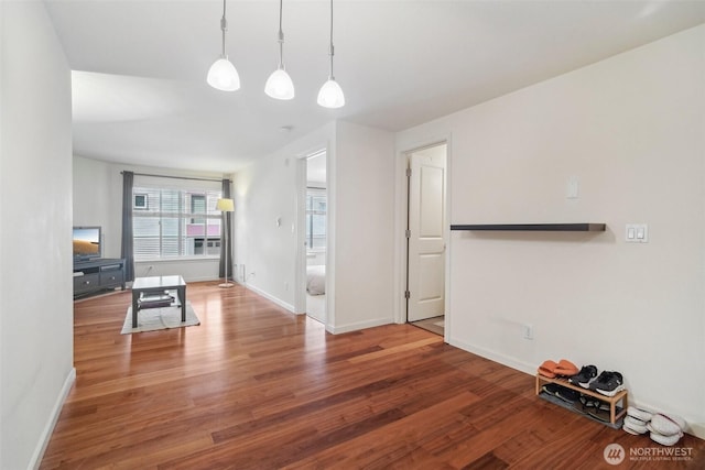 unfurnished living room featuring baseboards and wood finished floors