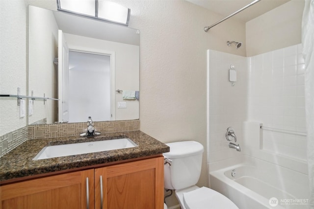 full bathroom featuring washtub / shower combination, vanity, decorative backsplash, toilet, and a textured wall