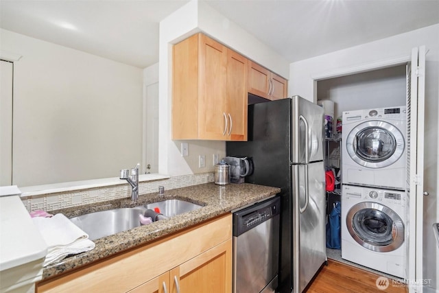 3045 20th Ave W Unit 208, Seattle, WA 98199 - kitchen featuring stacked washer and clothes dryer, dishwasher, a sink, light brown cabinets, and light stone countertops