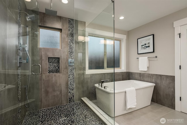 bathroom featuring tile walls, tile patterned flooring, a stall shower, a soaking tub, and recessed lighting