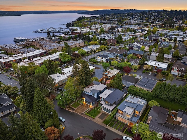 aerial view at dusk featuring a water view