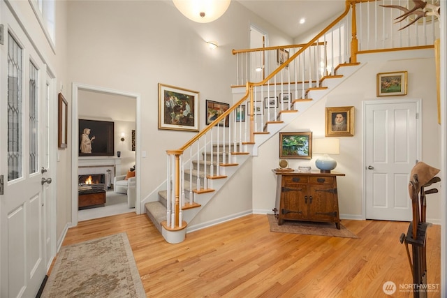foyer entrance featuring a high ceiling, wood finished floors, and stairway