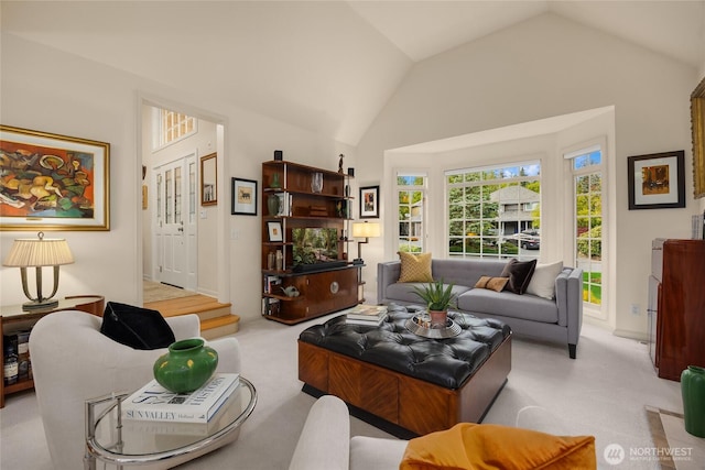 living area featuring carpet and vaulted ceiling